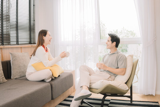 Happy Asian couple enjoying time together in their new home
