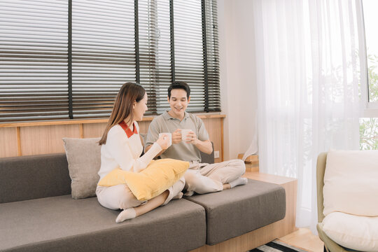 Happy Asian couple enjoying time together in their new home