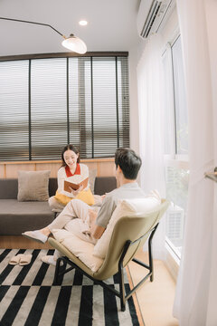 Happy Asian couple enjoying time together in their new home