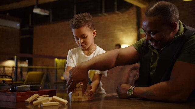 Father and son playing wooden block tower game