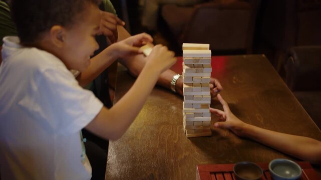 Black family playing wooden block tower together