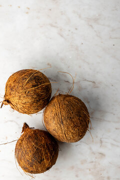 Closeup of coconuts on a white marble surface 