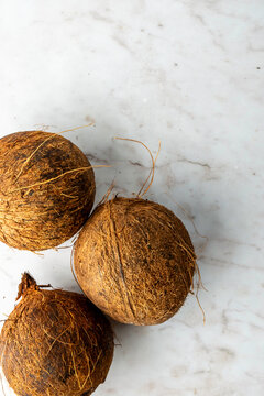 Closeup of coconuts on a white marble surface 
