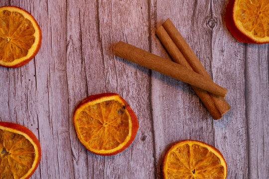 Dehydrated Orange Slices and Cinnamon Sticks on a Wooden Background