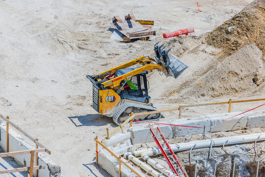 Close up view of Caterpillar compact track loader working at construction site. Miami Beach. USA. 