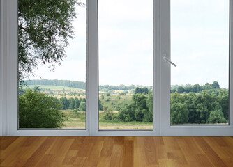 Fototapeta premium A view from the window of a landscape with green slopes and stretches of forest.