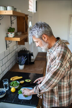 Senior man preparing healthy breakfast in home kitchen