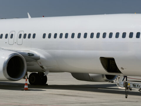 View of a white passenger airplane parked on the tarmac with a jet engine and ground support equipment visible at Kars Airport in Kars, Kars, Turkiye.