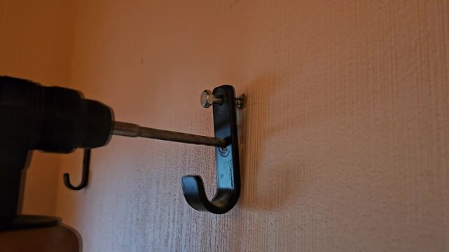 Drilling and installing a wall hook at home in a simple process