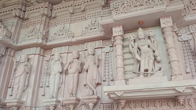 Intricate stone carving of Hindu deities and traditional idols inside a temple architecture