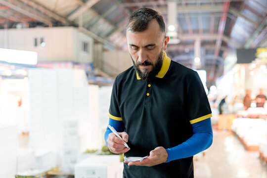 Fishmonger write order note at wholesale fish market