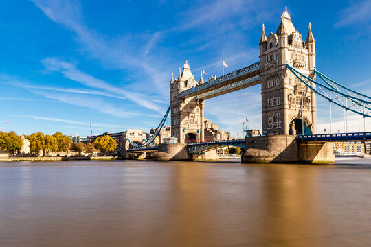 View of the iconic Tower Bridge spanning the River Thames under a clear blue sky in London, England, United Kingdom.