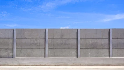 Precast concrete boundary wall panels under bright blue sky. Sturdy industrial barrier, security fence texture, or durable construction project background with copy space. © Prapat