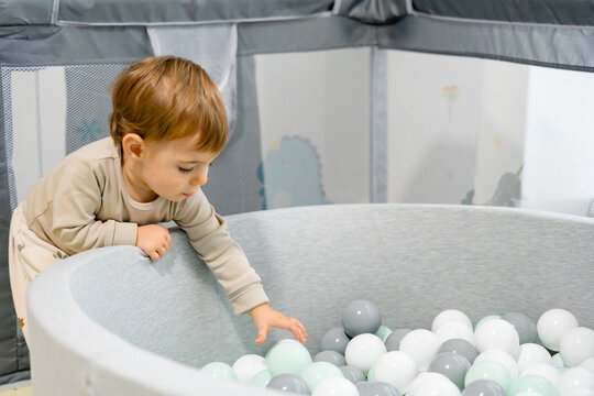 Toddler playing in soft ball pit at home play area