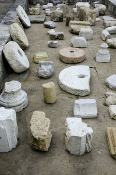 Ancient stone fragments and millstones arranged outdoors
