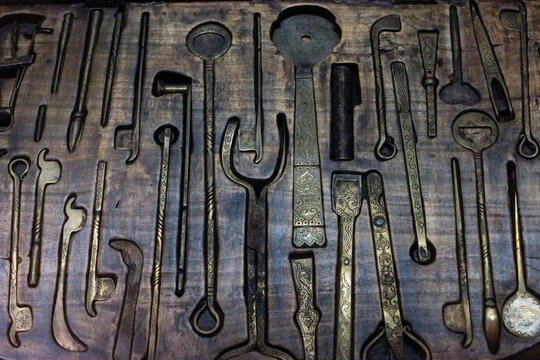 Vintage hand tools on a wooden pegboard
