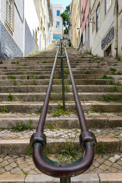 Steep stone stairway with pedestrian railing in Lisbon