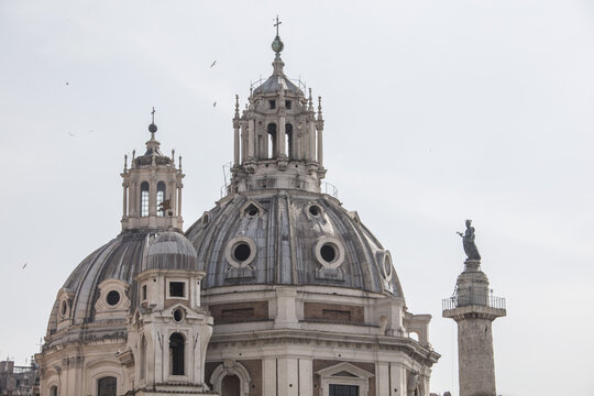 View of the twin domes of the churches of Santa Maria in Montesanto and Santa Maria dei Miracoli with a classical column in the background in Rome, Lazio, Italy.