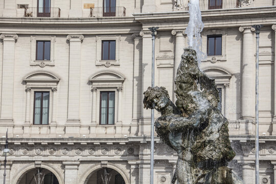 View of the Fountain of the Naiads with its central sculpture of Glaucus and spraying water, set against a classical building in Rome, Lazio, Italy.