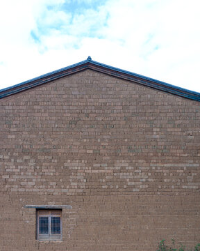Traditional Chinese mud brick building gable wall with small lattice window