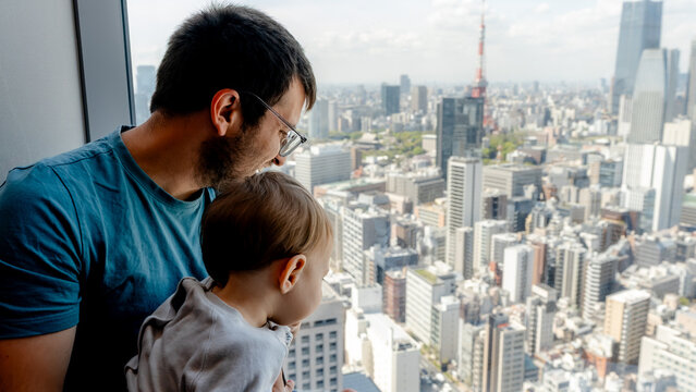 Father and child gaze over Minato Tokyo skyline