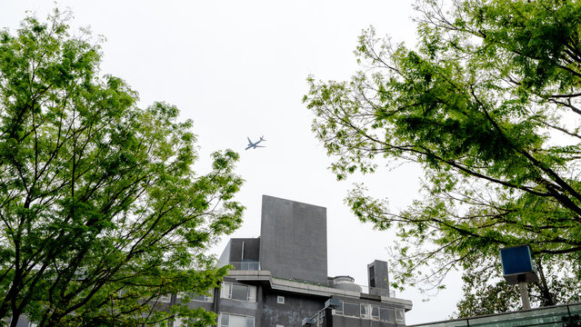 Airplane flying over building in Harajuku, Tokyo