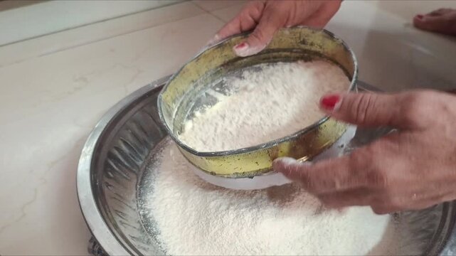 Close-up of woman hands sifting wheat flour and kneading dough in traditional dish
