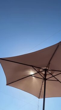 Beach parasol seen from below against a clear blue sky