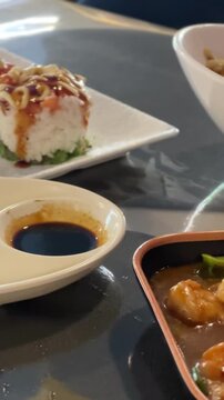 Dipping a gyoza dumpling in soy sauce at a restaurant table