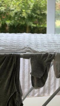 Socks and towel drying on a clothes rack indoors
