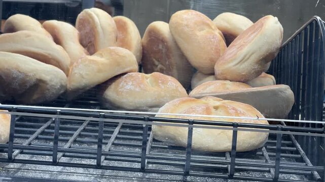 Crusty bread rolls on display at a bakery