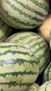 Watermelons stacked at an outdoor market stall