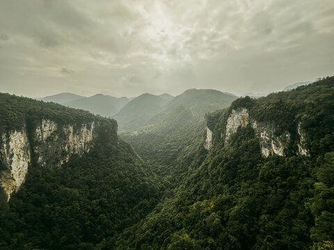 View of the dramatic limestone cliffs and lush forest landscape of Zhangjiajie under a cloudy sky in Zhangjiajie, Hunan, China.