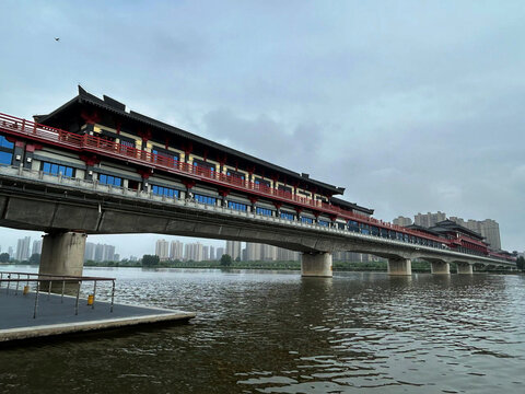 View of the Xianyang Ancient Ferry Bridge with its traditional Chinese architecture and red railings spanning the Wei River in Xianyang, Shaanxi, China.