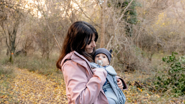 Mother holding baby during hike in Pelegrina woods