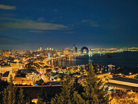 View of the illuminated Baku skyline at night, featuring the iconic Flame Towers and Crescent Hotel along the Caspian Sea coastline in Baku, Baku, Azerbaijan.
