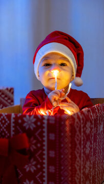 Child in Santa hat holding glowing Christmas light