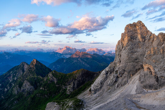 View of the rugged peaks of the Dolomites at sunset with rocky slopes and lush green mountain ridges in San Martino di Castrozza, Trentino-Alto Adige, Italy.