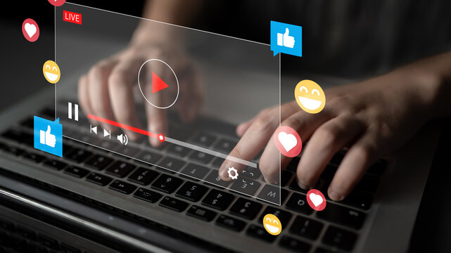 A close-up view of hands typing on a laptop keyboard with a digital streaming interface displaying social media reactions like likes and hearts, symbolizing engagement in content creation. Ledger