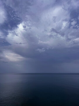 Cloudy sky over calm ocean before storm vertical 