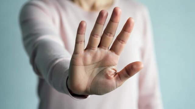 Person holding hand up in a stop gesture