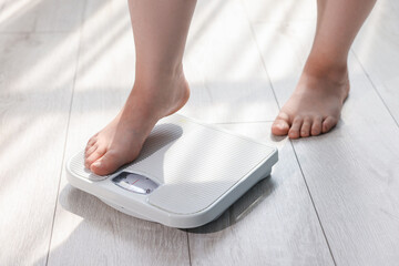 Fototapeta premium Overweight woman on scale at home, closeup