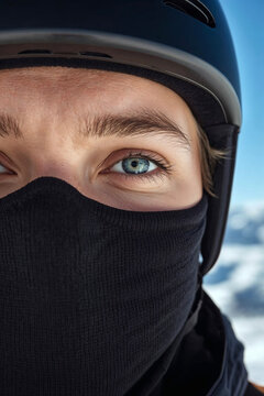 snowboarder with blue eyes wearing helmet and black balaclava