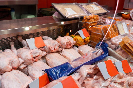 Raw chicken cuts displayed in a butcher shop counter case