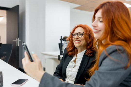 MBA mentor and student review smartphone in office