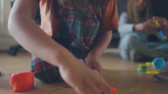 Boy rolling a textured pin across modelling clay on the living room floor