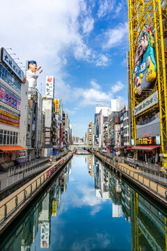 Cityscape of Dotonbori in Osaka with reflections on Dotonbori Canal. It's the premier entertainment hub of Osaka with more than 400 years history dating back to 1612 in the Edo period.