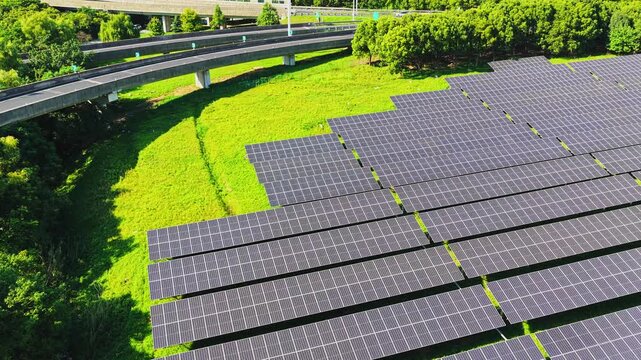 Drone flying forward above a solar farm and highway interchange