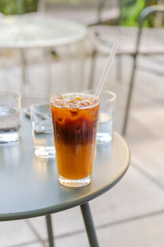 Iced bumble coffee with orange juice on an outdoor cafe table