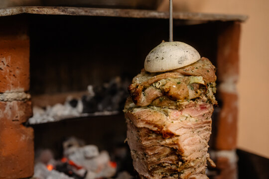 Mexican street food cooking roasted pork on vertical spit